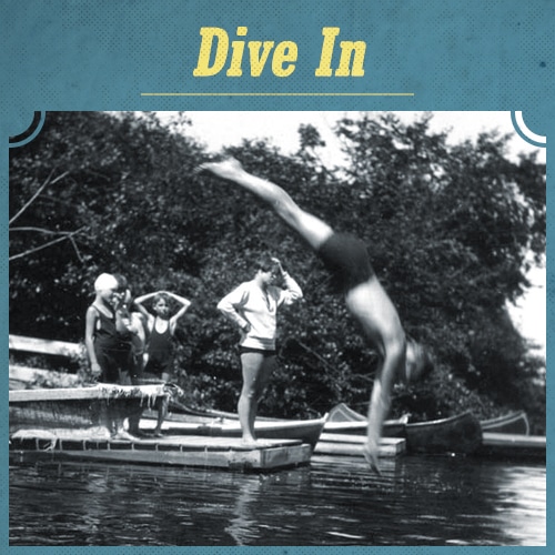 Vintage men diving into river from dock.