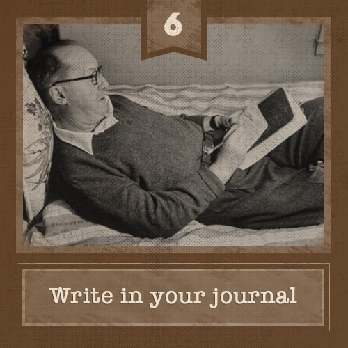 Man lying in bed writing in journal.