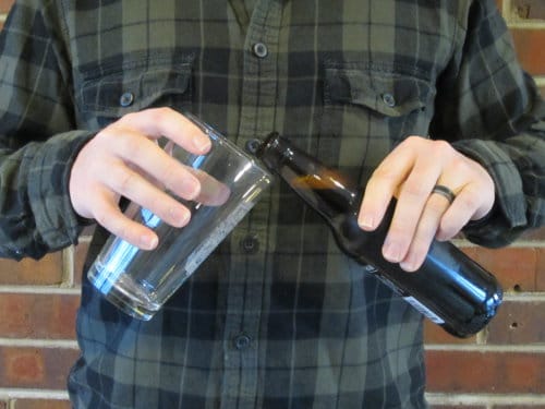 Man pouring beer into pint glass.
