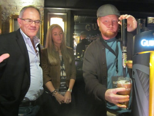 Man pouring beer into pint glass.