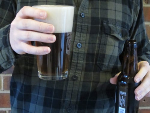 Man pouring beer into pint glass.