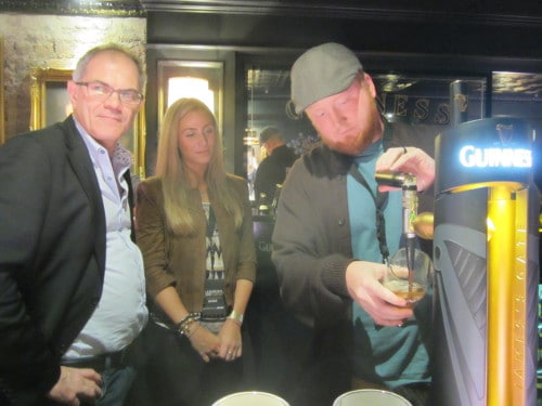 Man pouring beer into pint glass.