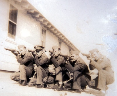 A group of men in uniform, who have just completed their basic training, posing for a photo.