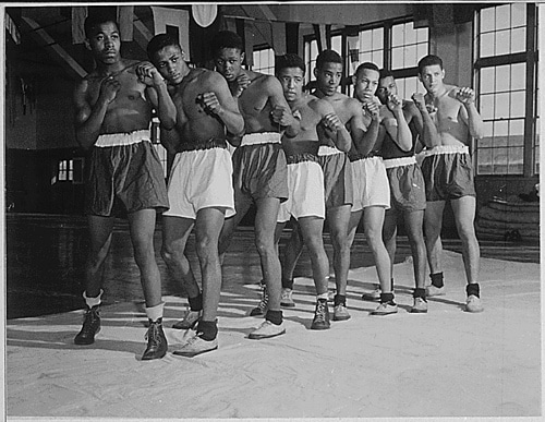 Black and white photo of a group of fighters posing during a workout.