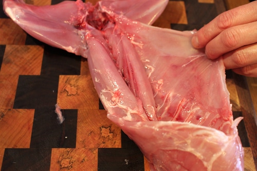 Man removing the belly skin of rabbit.