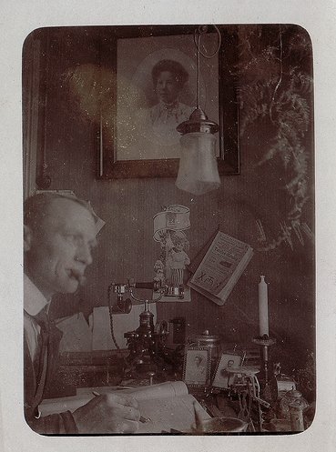 A man passionately engaged in his vocation at his desk, capturing an old photo.