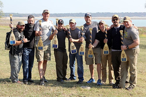 Charlie squad holding a paddle in hands.