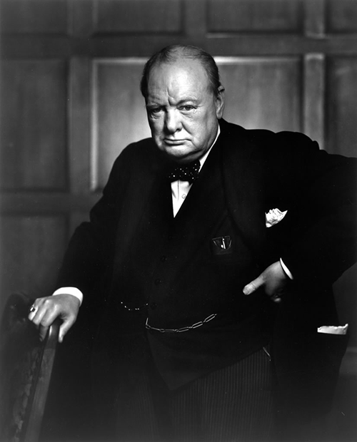 A black and white photo of a man in a suit, perfect for motivational posters inspired by Winston Churchill.