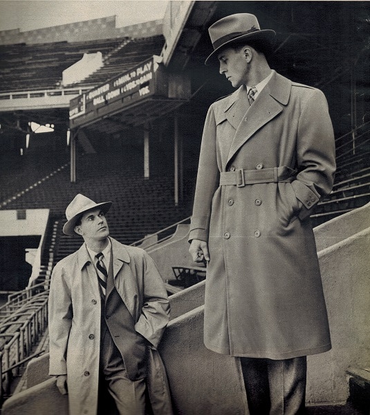 Vintage college men wearing rain coats in stadium.