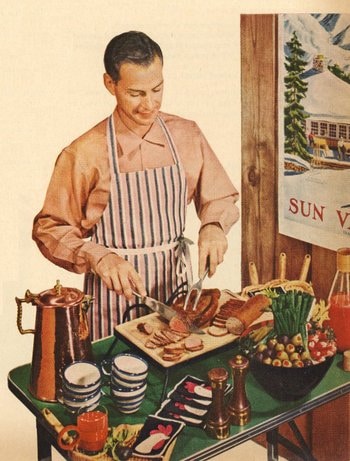 A man in an apron is preparing food from a Valentine's Day menu on a table.