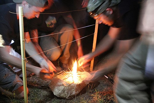Muster men starting fire without matches.