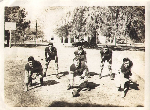 A group of men participating in gut-busting conditioning drills on the gridiron as they pose for a photo.