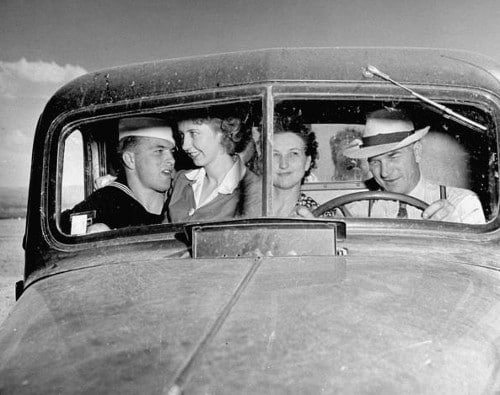 A smooth group of people bringing their girlfriend, sitting in the back seat of a car.