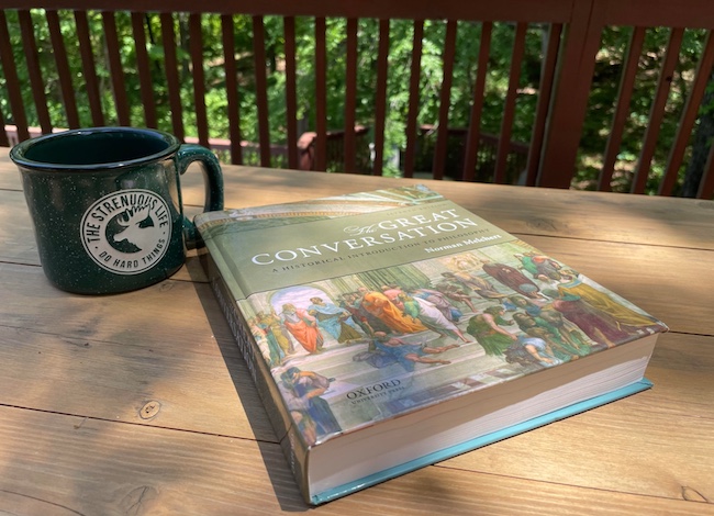 An important textbook sits on a table next to a coffee mug.