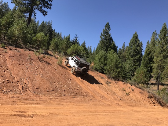 A SAR jeep on a slop in woods.