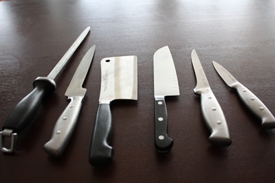 A group of kitchen knives arranged on a table.