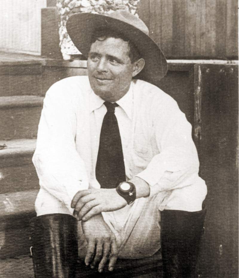 Jack London sitting on porch wearing pocket watch wristlet.
