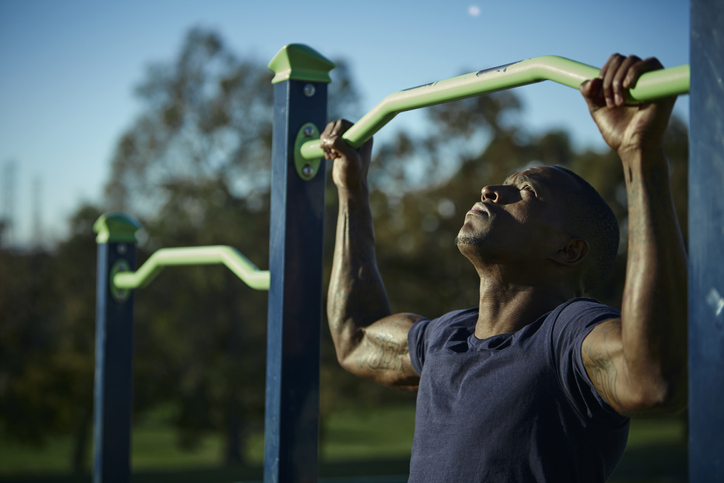 Man doing pull ups for body fitness at outside.
