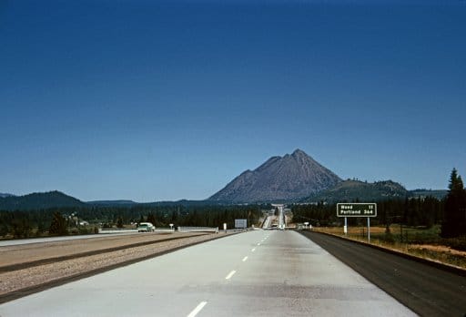 Embark on a great American road trip as you drive across the country, with a majestic mountain in the background.