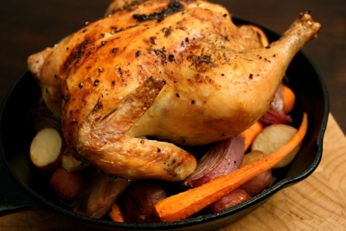 In the kitchen, master the fundamentals of cooking by preparing a delicious whole roasted chicken with tender carrots and crispy potatoes in a cast iron skillet.