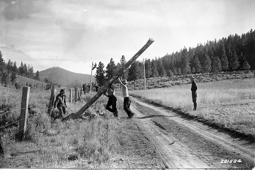 A black and white photo depicting a group of men on a dirt road, making a difference.