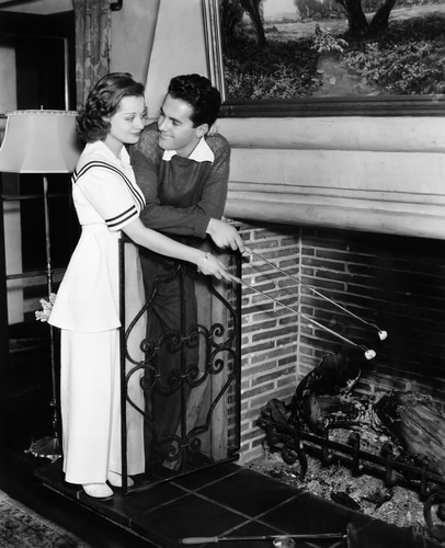 Vintage couple roasting marshmallows in home.