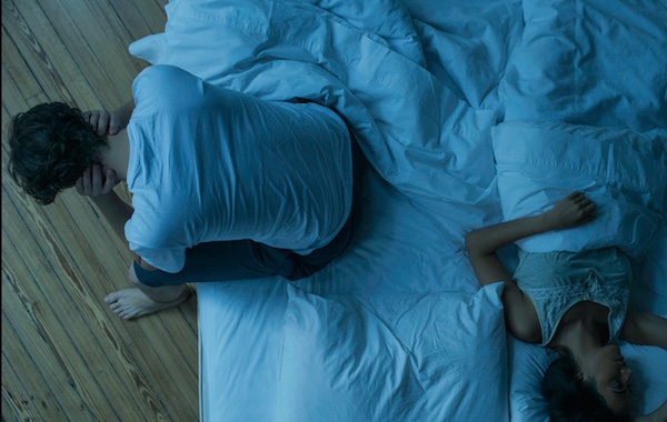 A man and woman are resting on top of each other in bed, seeking better sleep.