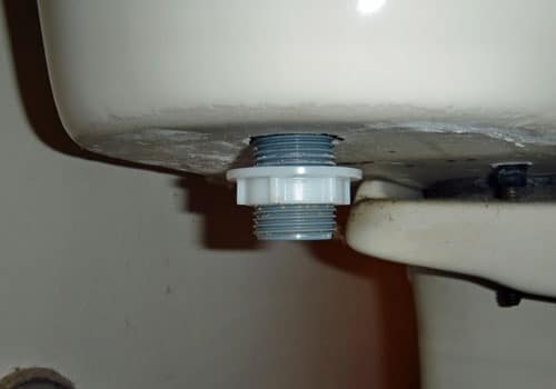 Plastic nut under toilet close up photo.