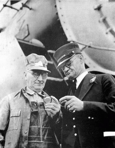 Vintage train engineers syncing watches.