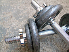 A pair of dumbbells on a concrete floor, perfect for a stronger workout.