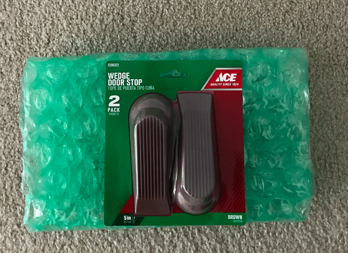 A pair of green plastic shoe covers resting on top of bubble wrap, perfect for DIY protection.