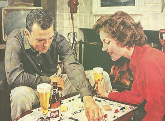 Vintage couple is drinking and playing monopoly.