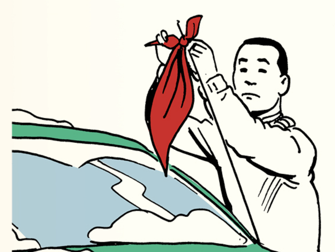 A man is putting a red cloth on the windshield of a stranded car.