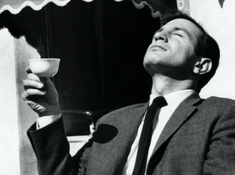 An important man in a suit holding a cup of coffee.