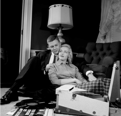 Vintage couple cuddling while listening to vinyl.